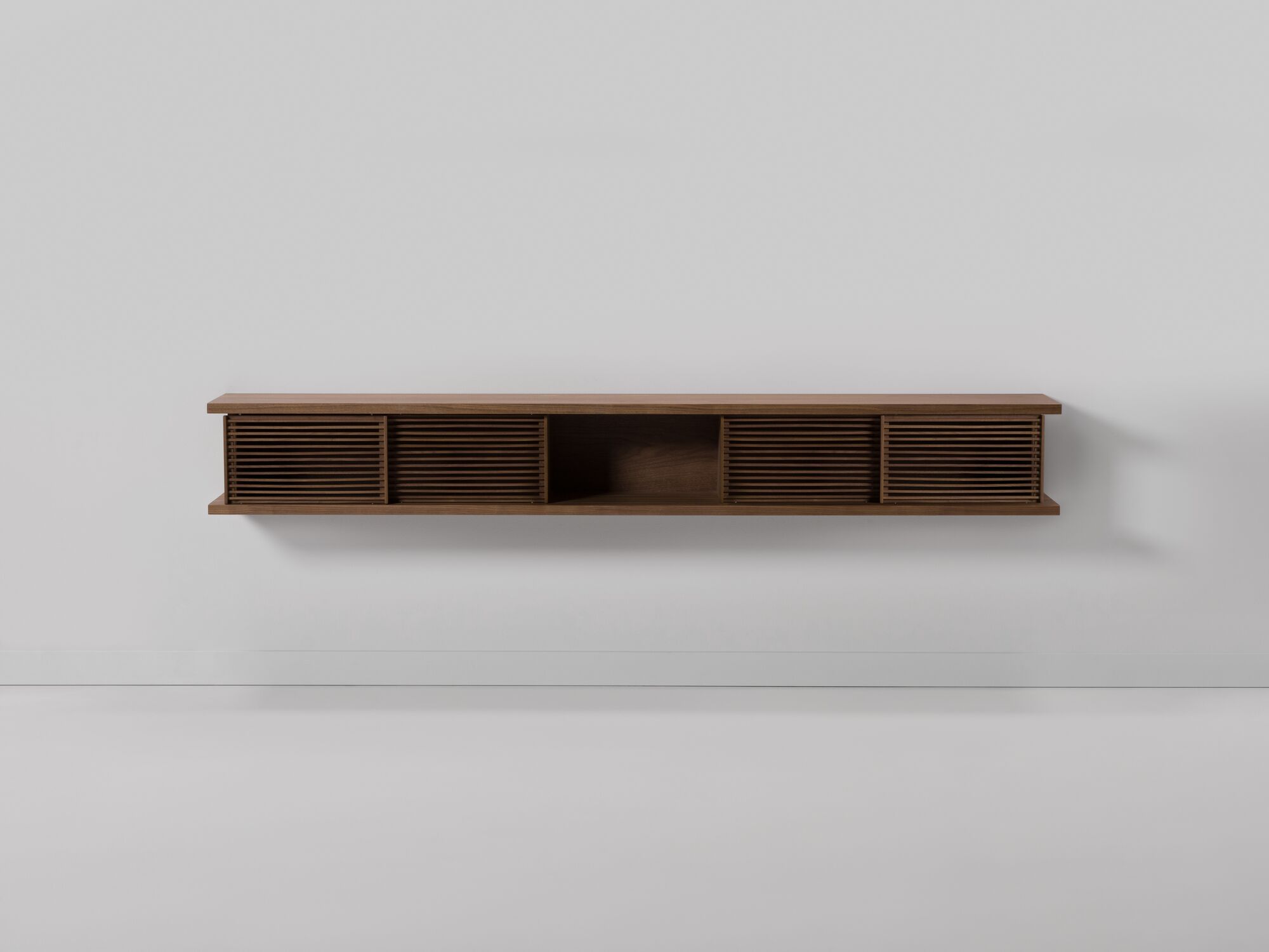 Front view of large walnut floating media unit with slatted doors